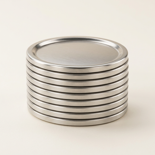 Mason jar lids on a premium warm ivory background with soft studio lighting